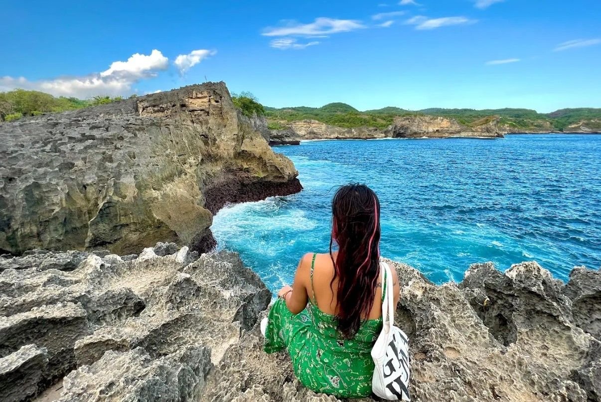 Angel Billabong Nusa Penida - Seorang wanita berfoto di atas karang Angel Billabong