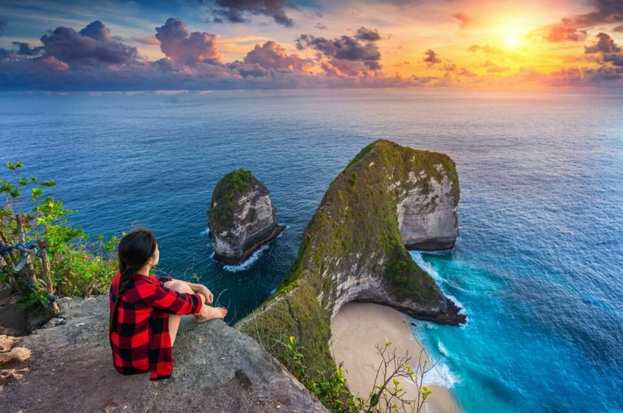 Kelingking Beach Nusa Penida - Seorang wanita berfoto di atas tebing Kelingking Beach saat sunset