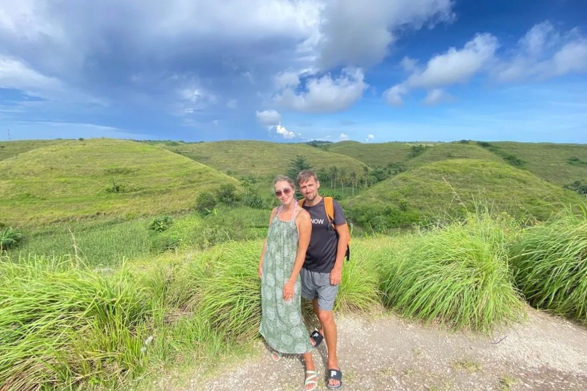 bukit teletubbies nusa penida bali - sepasang wisatawan asing berfoto dengan background Bukit Teletubbies